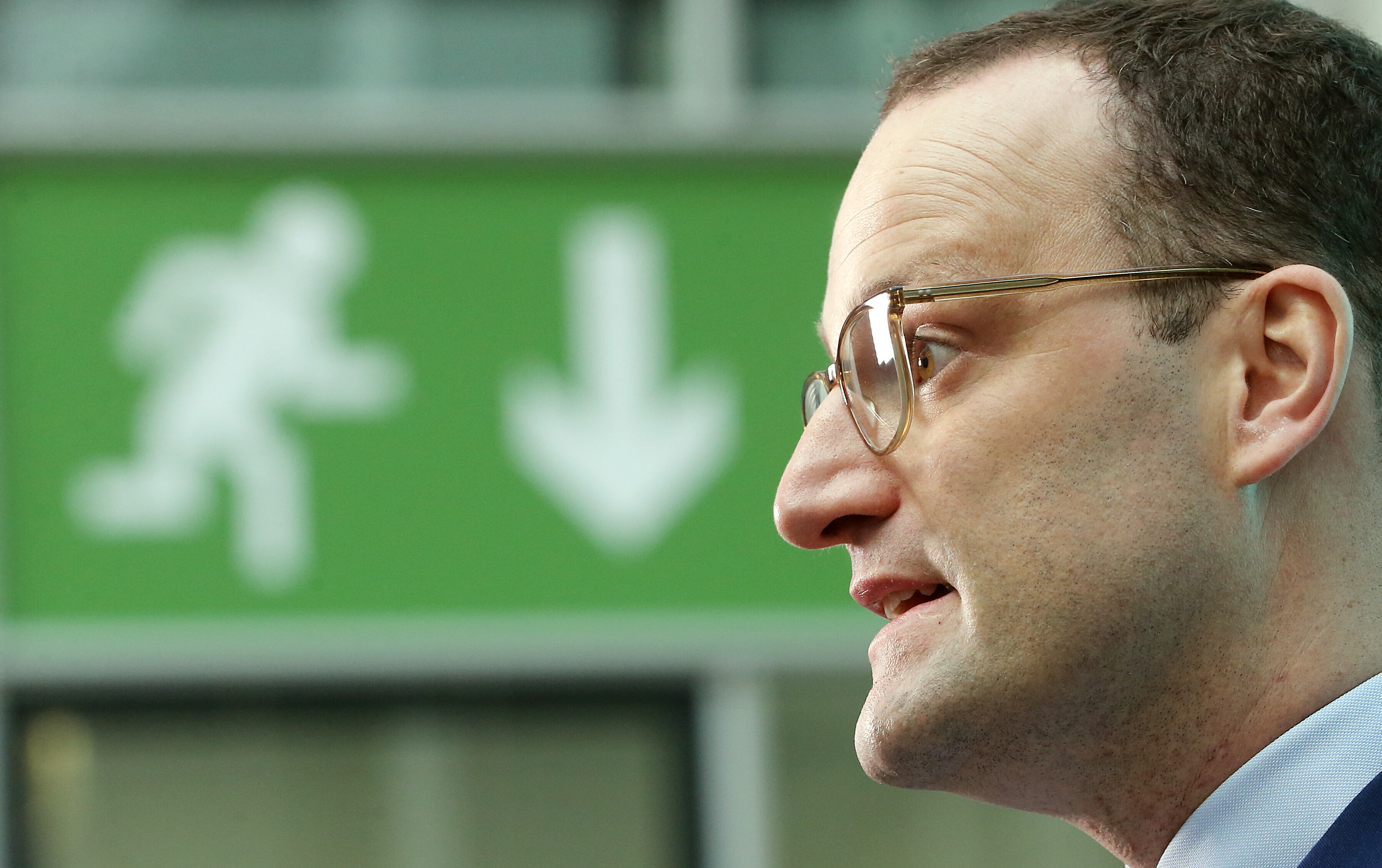 31.10.2018, Berlin: Jens Spahn (CDU), damals Bundesgesundheitsminister, vor einem grünen Schild im Atrium des Bundesgesundheitsministeriums, das mit einem Pfeil zum Ausgang weist