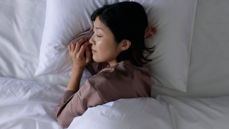Eine schlafende Frau liegt in ihrem Bett