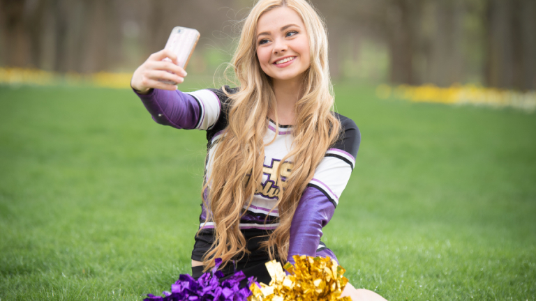 Cheerleader mit Handy beim Aufnehmen eines Selfies