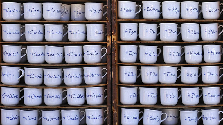 Ein Regal voller Tassen, auf denen diversen Vornamen stehen.