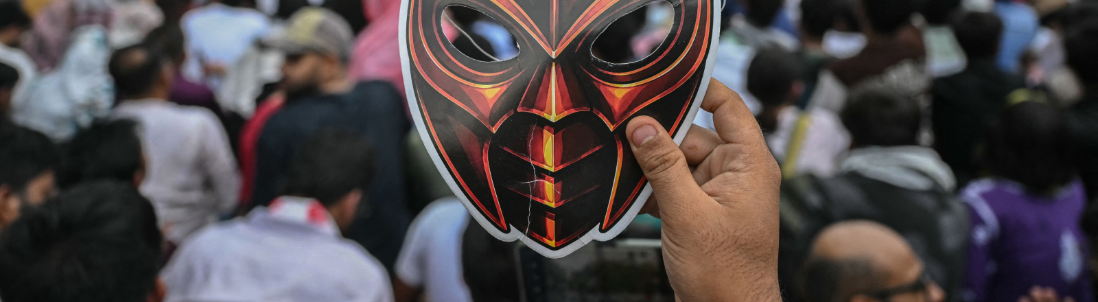 Ein Unterstützer der Cockroach Janta Party (CJP) hält während eines Protests in New Delhi am 6. Juni 2026 eine Maske in Kamera