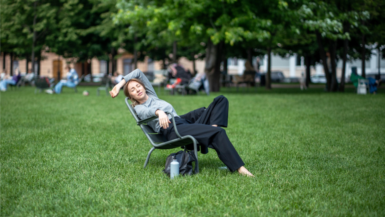 Eine Frau beim Mittagsschlaf auf einer Wiese.