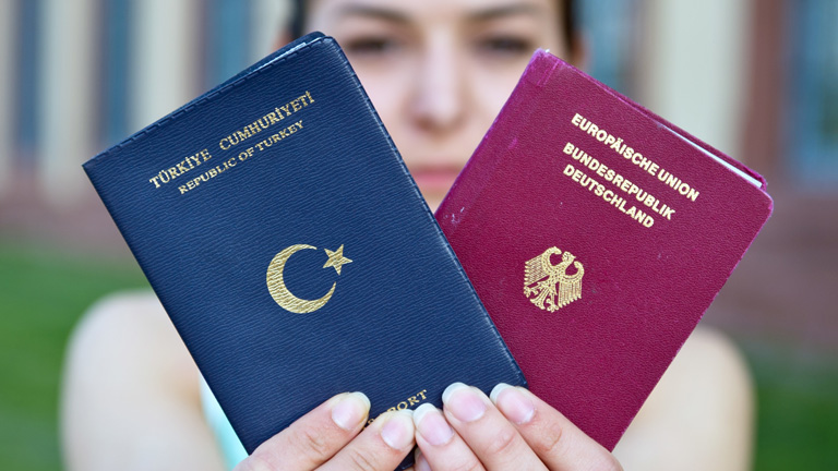 Eine Deutsch-Türkin hält ihre beiden Pässe hoch