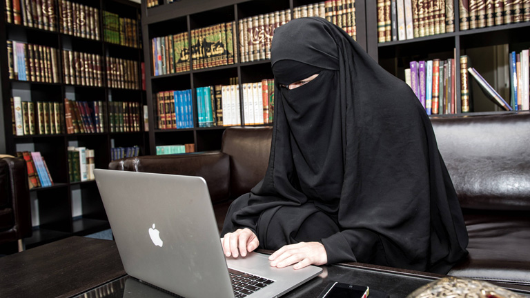 Frau im Niqab in einer Bibliothek