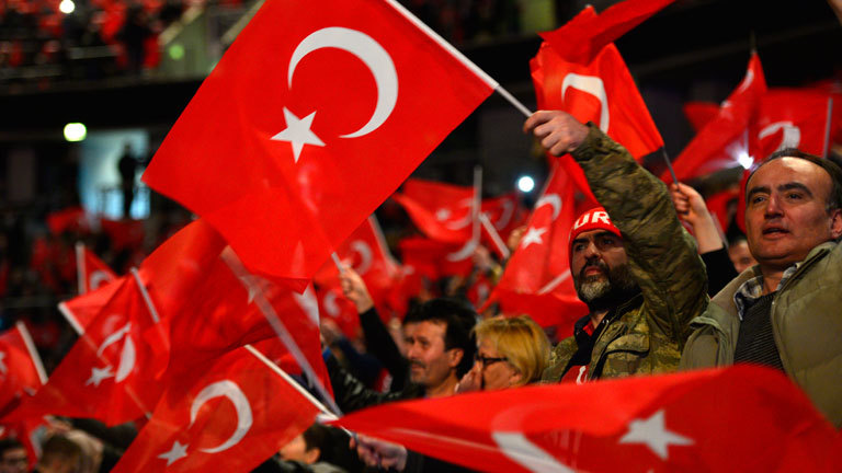This file photo taken on February 18, 2017 shows participants waving Turkish flags during an event with the Turkish Prime Minister to promote a constitutional referendum in Oberhausen, western Germany. Turkish politicians will hold no further rallies in Germany ahead of April's referendum on expanding President Recep Tayyip Erdogan's powers, his AKP party said on March 20, 2017 amid a heated diplomatic row.