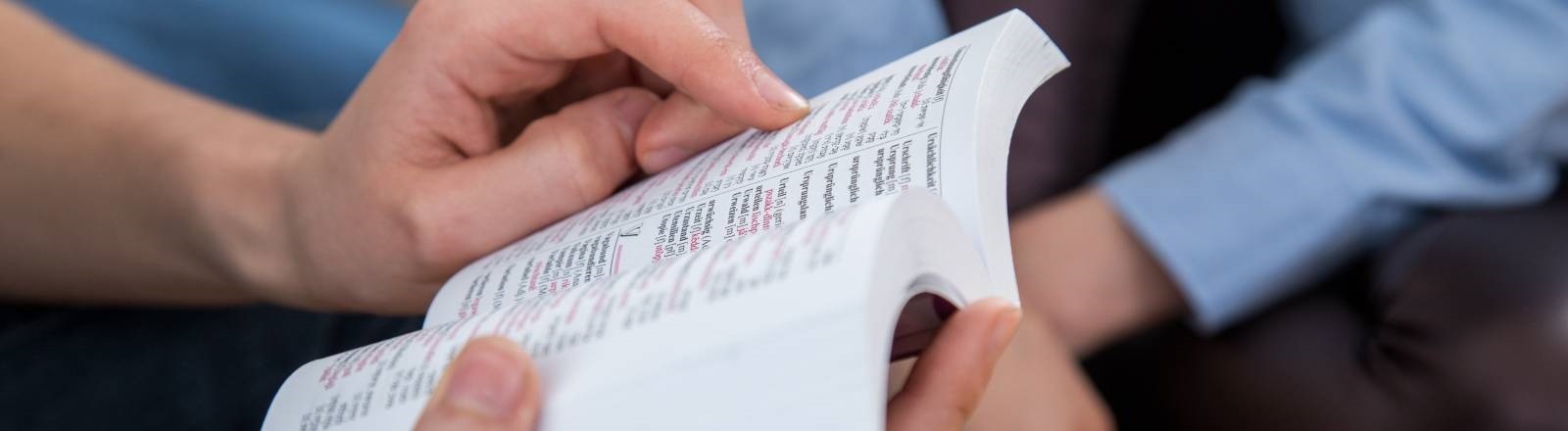 Eine Person hält ein Wörterbuch in den Händen