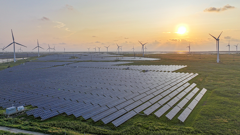 In Ostchina fällt der Blick auf ein großes Solarkraftfeld, am Horizont stehen Windkrafträder. (15.08.2024)