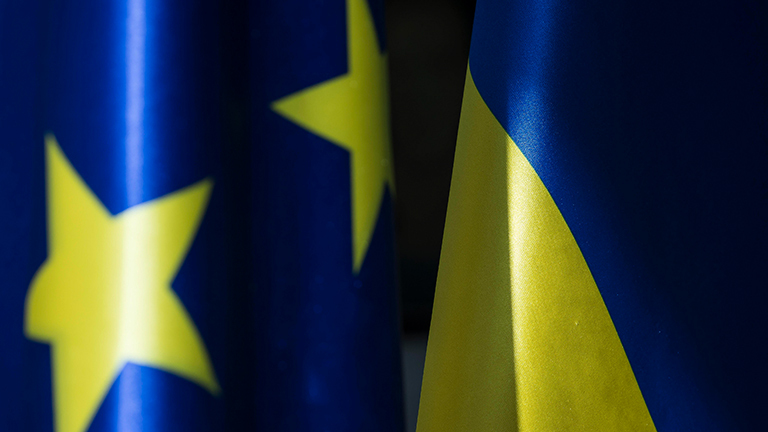 Zwei Fahnen der Europäischen Union und der Ukraine nebeneinander. Beide mit den Farben blau und gelb.