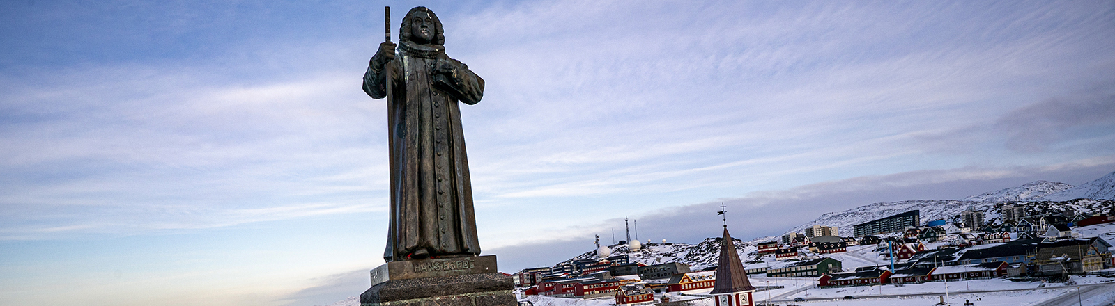 In der grönländischen Stadt Nuuk steht eine Statue des Missionars Hans Egede. Im Hintergrund ist die Stadt zu sehen.