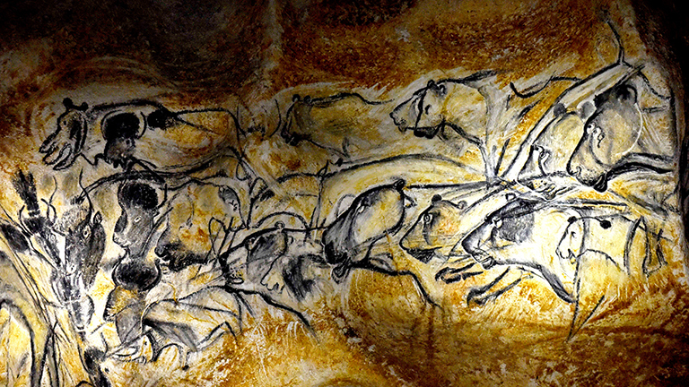 Auf einem Felsen sind Malereien, sie zeigen Tiere, vielleicht Ochsen und Pferde. Es ist eine Nachbildung von Zeichnungen in der Chauvet-Höhle.