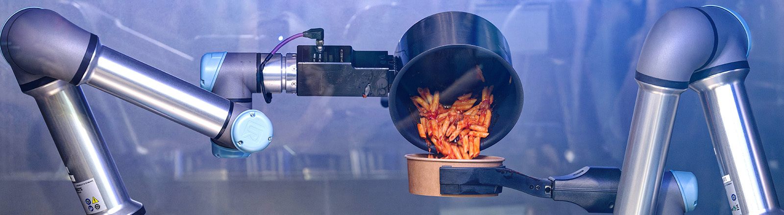 Eine Roboterarm kippt ein vom autonomen KI-Kochroboter CA-1 Nudelgericht in eine Schüssel.