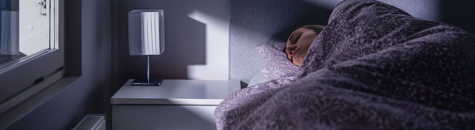 Eine Frau liegt in einem Bett und schläft