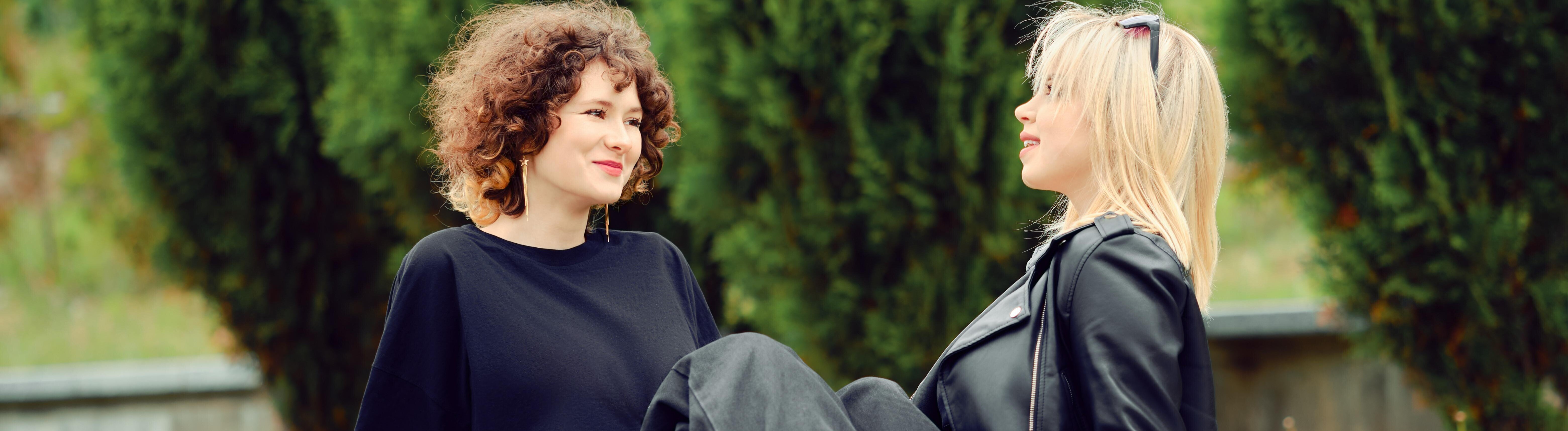 Zwei junge beste Freunde sitzen nebeneinander im Park