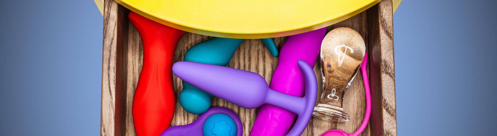 Sexspielzeuge in bunten Farben liegen in einer offenen Schublade