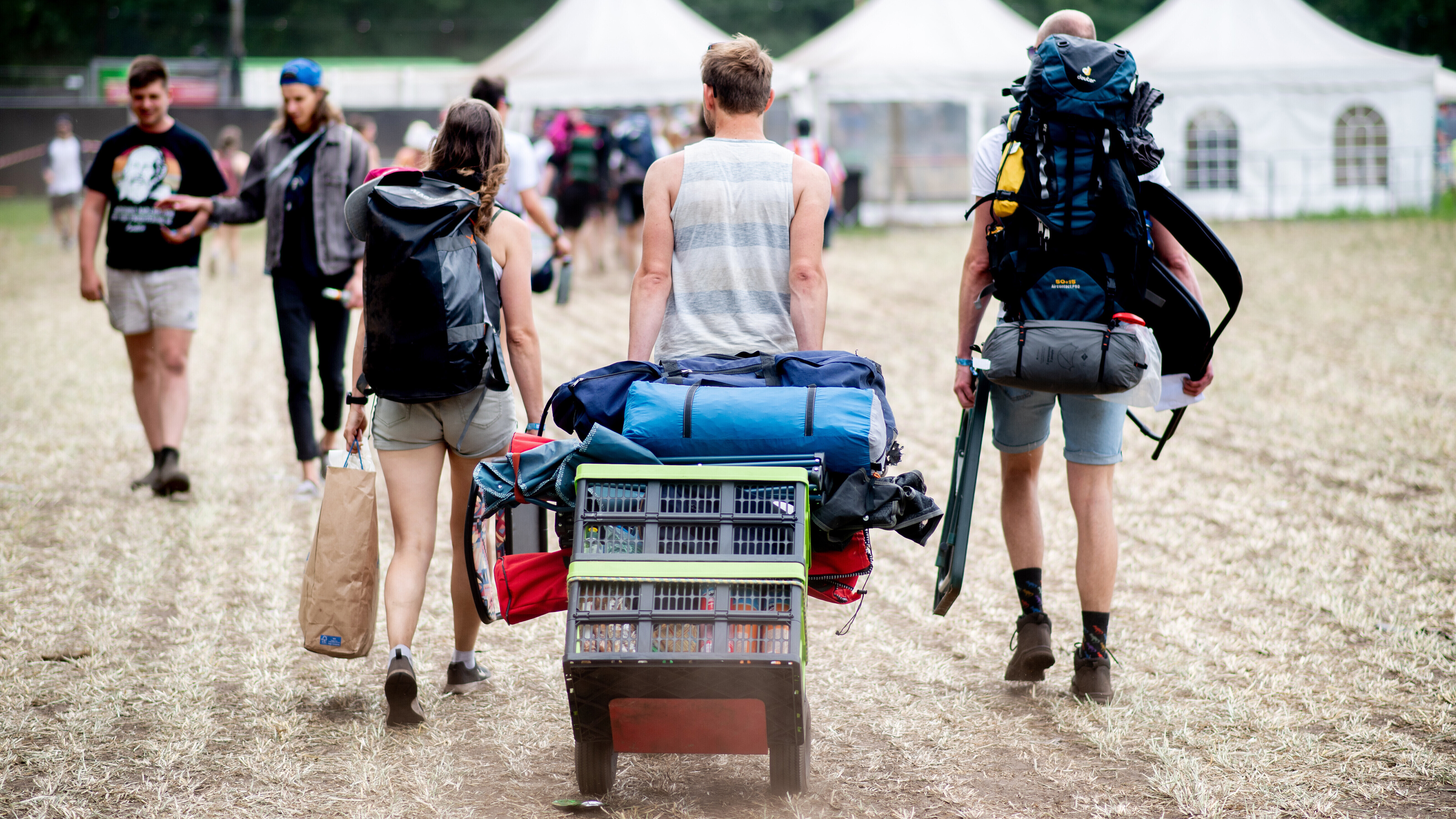 Besucher transportieren ihre Zelte und Gepäck mit einer Sackkarre zum Zeltplatz des Hurricane Festivals 2023.