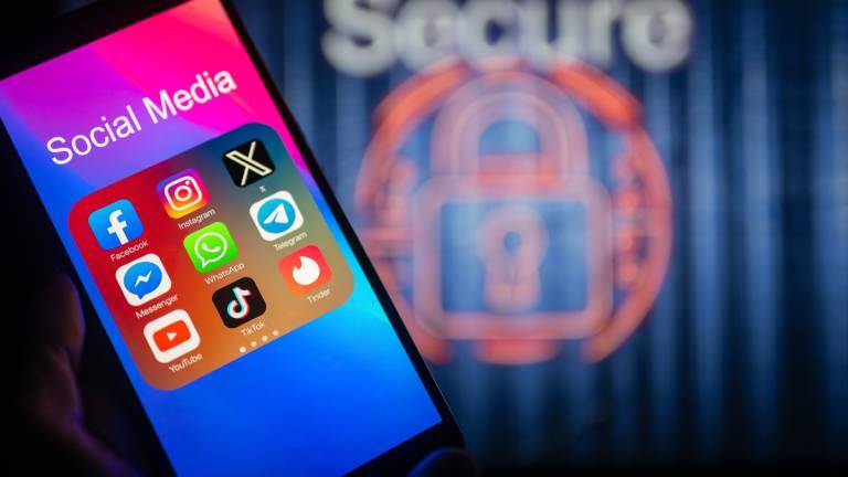 Social-Media-Symbole werden auf einem Smartphone angezeigt, im Hintergrund ist ein Sicherheitsschloss zu sehen.