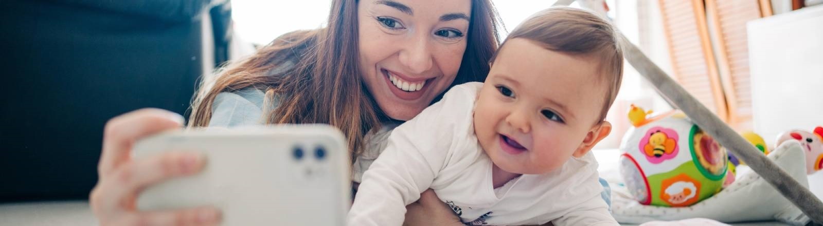 Eine Frau macht von sich und einem Baby ein Selfie