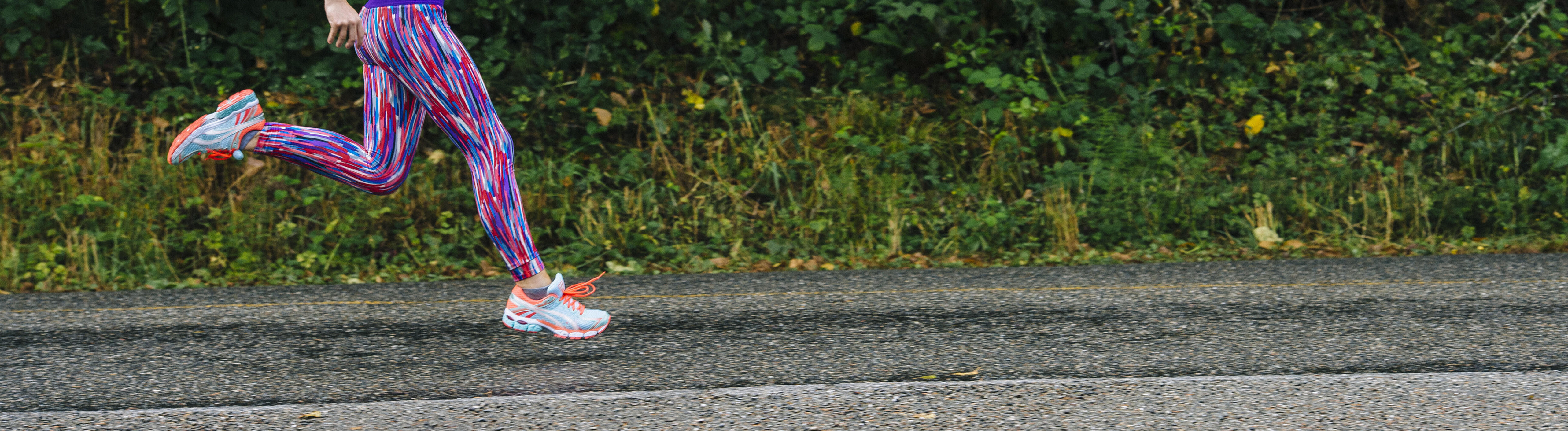 Eine Joggerin joggt auf Asphalt