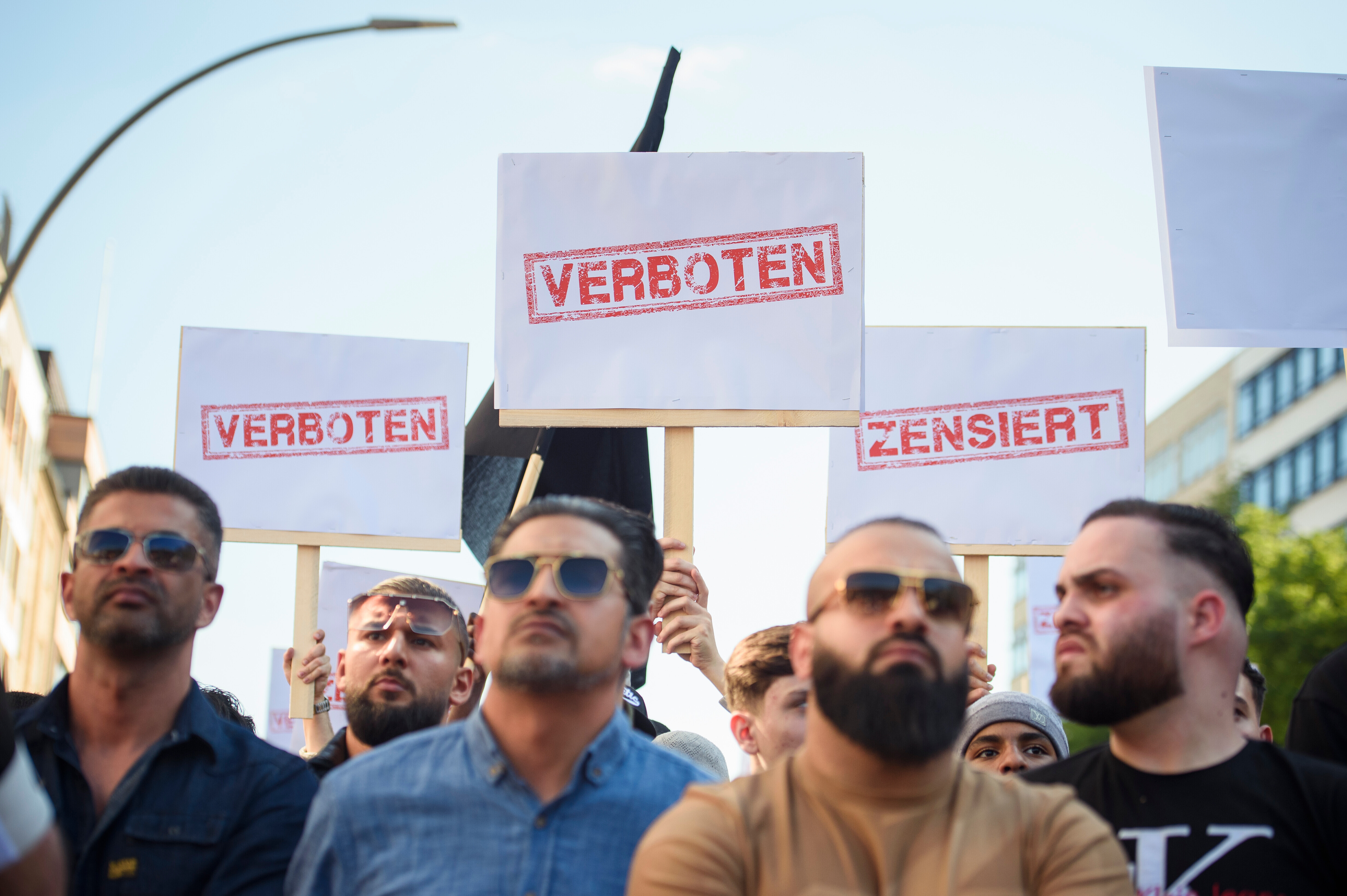 Demonstranten halten Schilder mit den Aufdrucken «Verboten» und «Zensiert» auf einer Kundgebung des islamistischen Netzwerks Muslim Interaktiv im Hamburger Stadtteil St. Georg in die Höhe (11.05.2023)