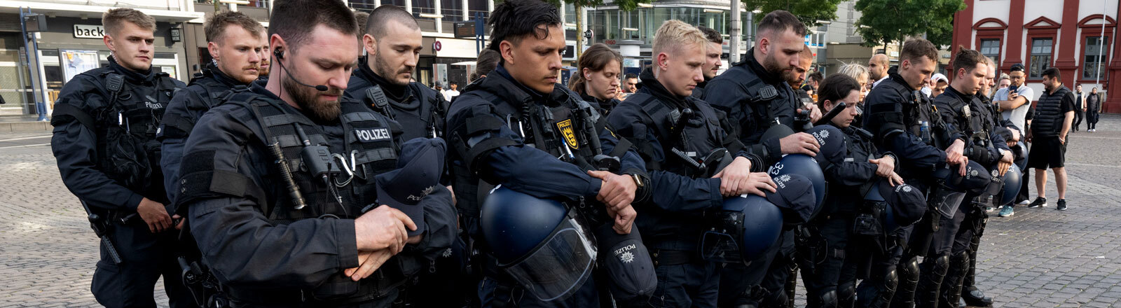 Minuten nach dem Bekanntwerden seines Todes trauern Polizisten auf dem Marktplatz in Mannheim um ihren getöteten Kollegen. Der Polizist war hier von einem Mann mit einem Messer niedergestochen und lebensgefährlich verletzt worden.