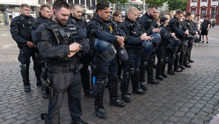 Minuten nach dem Bekanntwerden seines Todes trauern Polizisten auf dem Marktplatz in Mannheim um ihren getöteten Kollegen. Der Polizist war hier von einem Mann mit einem Messer niedergestochen und lebensgefährlich verletzt worden.