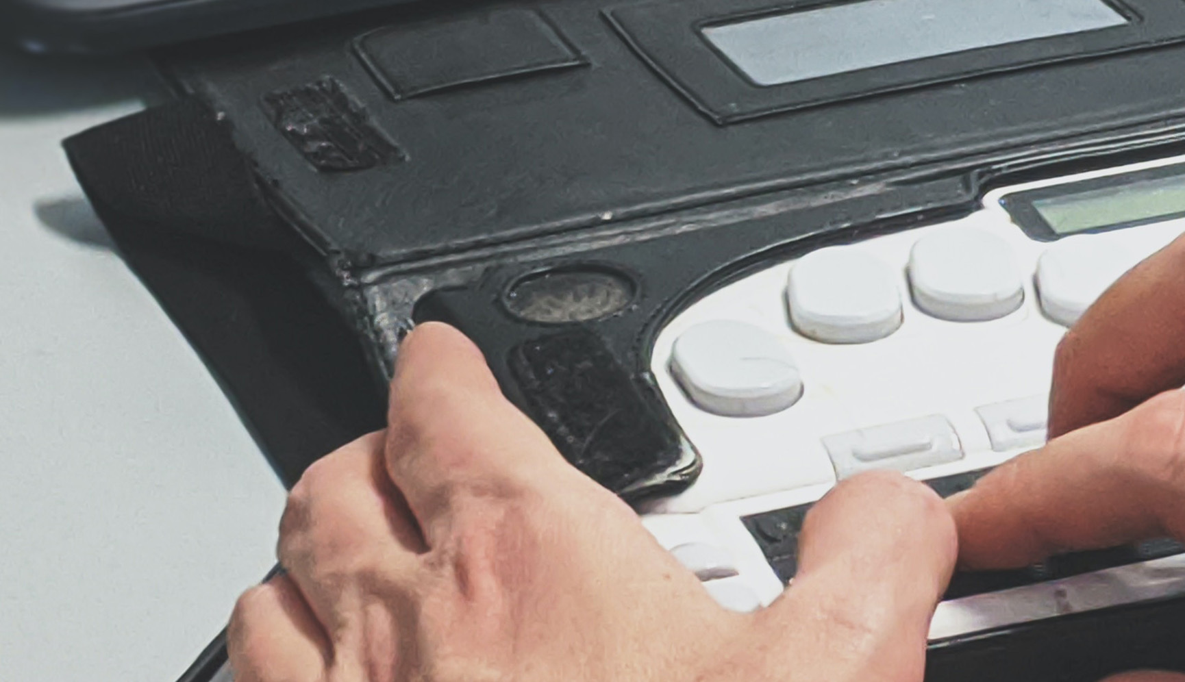 Daumen und Zeigefinger bedienen eine Braille Tastatur