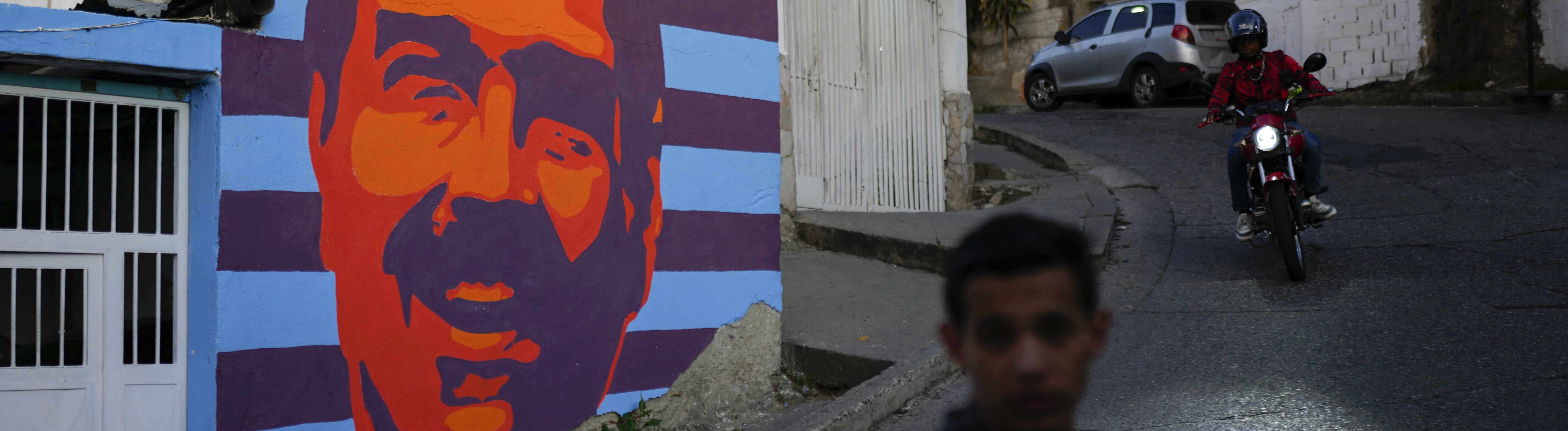 Zwei Mopedfahrer fahren in Caracas an einem Wahlkampf-Mural von Nicolás Maduro vorbei (Venezuela,17.07.2024)