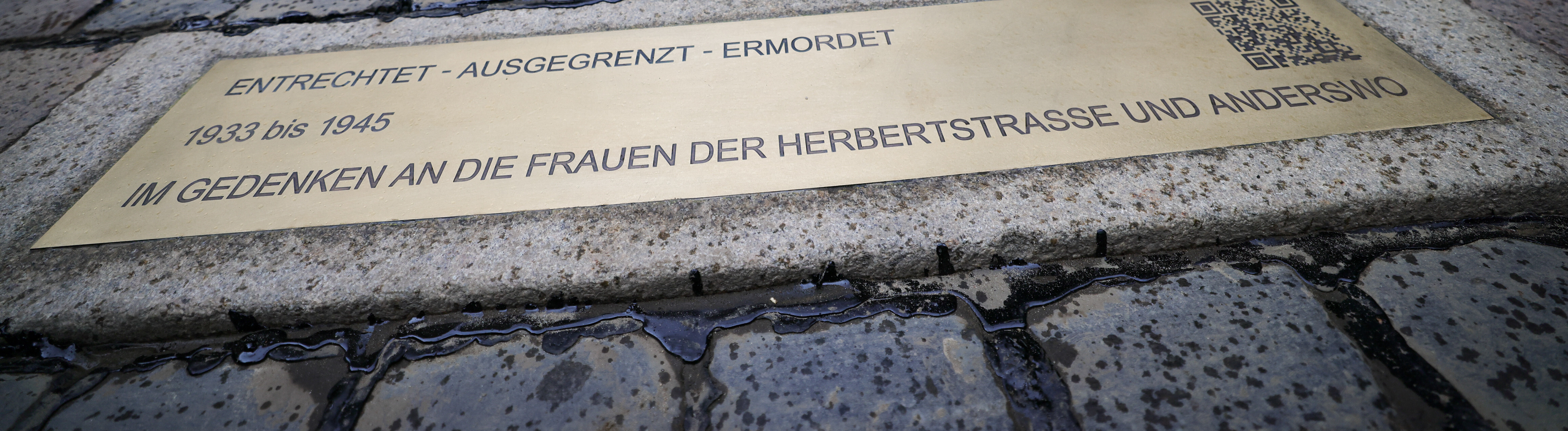 Ein Kantstein mit Gedenkplatte mit dem Text ««Entrechtet-Ausgegrenzt-Ermordet 1933-1945 Im Gedenken an die Frauen der Herbertstrasse und Anderswo»» liegt nach der Enthüllung vor dem Eingang zur Herbertstrasse an der Reeperbahn. Die geprägte Bordsteinkante zum Gedenken an die Sexarbeiterinnen zur NS-Zeit wurde durch die Initiative Lebendiges Kulturerbe St. Pauli e.V. und St. Pauli Kirche ermöglicht und verlegt.