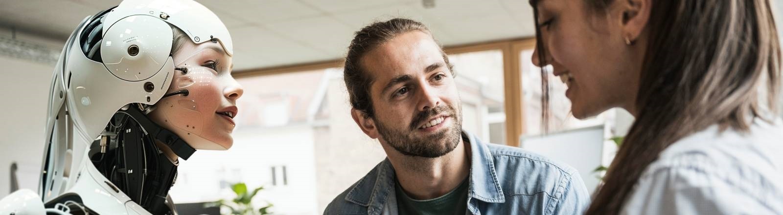 Zwei Mitarbeitende und ein Cyborg stehen zusammen