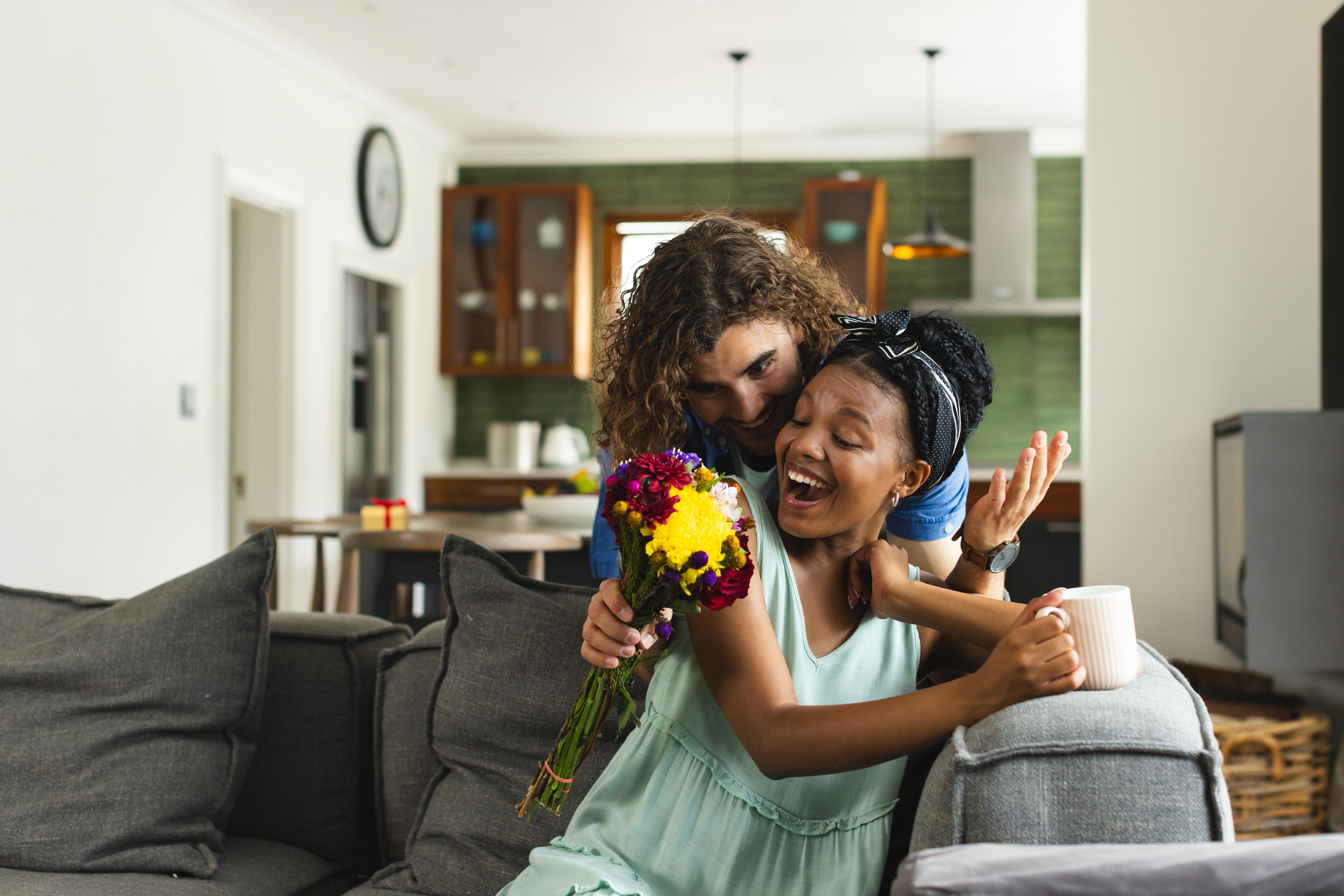 Ein Mann überrascht eine Frau mit Blumen