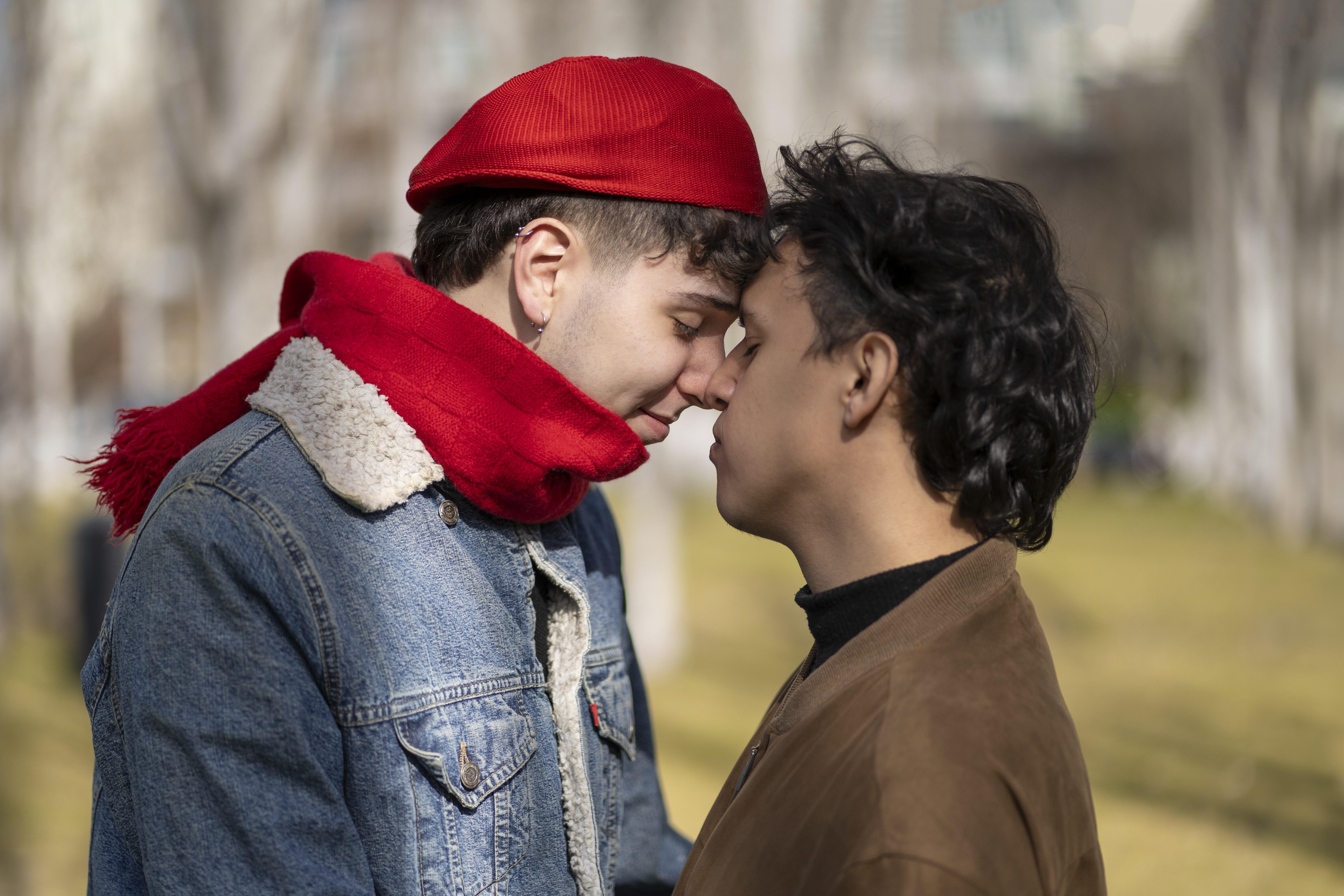Zwei junge Männer küssen sich in einem Park