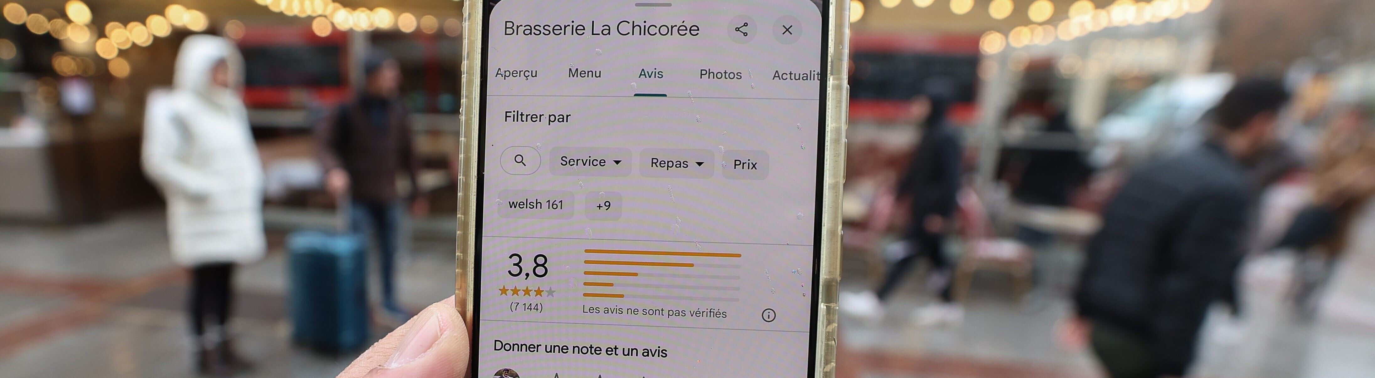 Ein Smartphone mit einer Restaurantbewertung vor einem Lokal