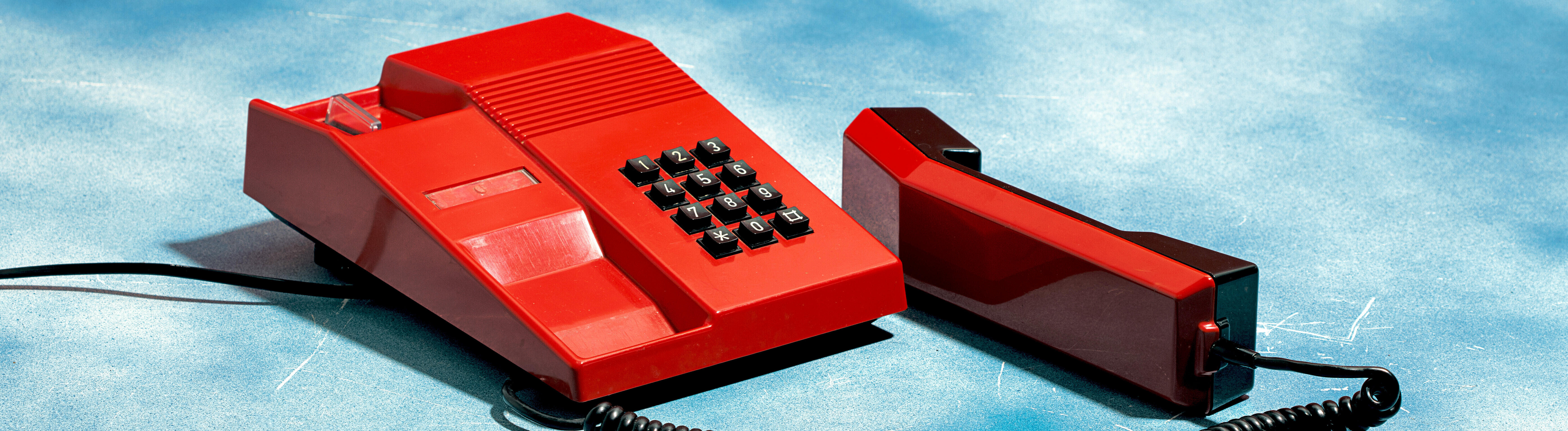 Altes rotes Telefon auf einem Wolkenhimmel-Hintergrund