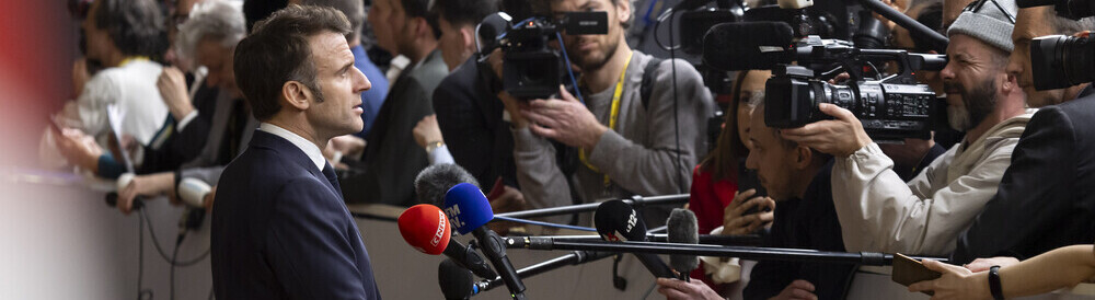 Emmanuel Macron gibt ein Pressestatement, vor ihm Kameras und Mikrofone