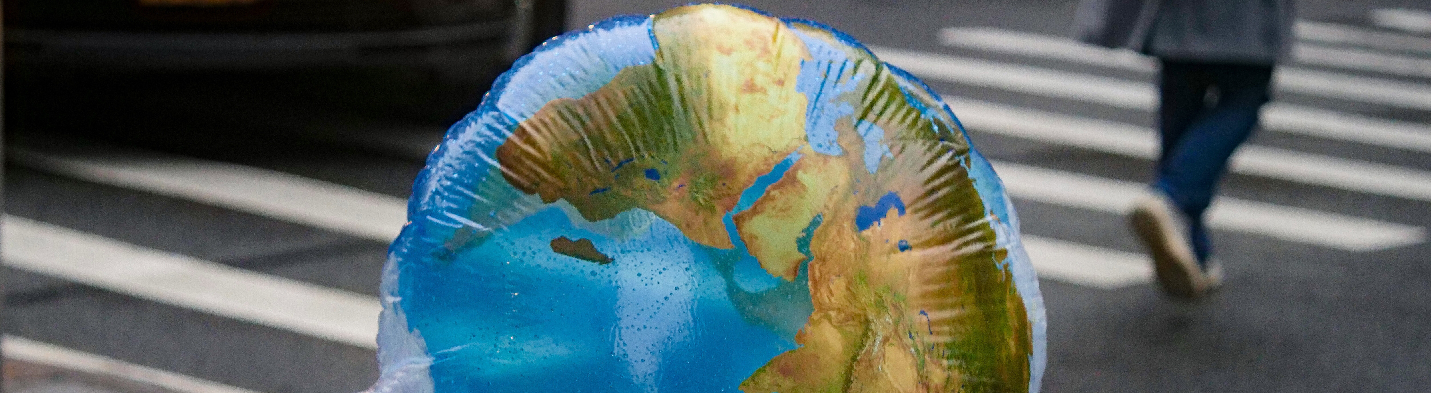 Ein Luftballon mit einer Weltkarte weht im Wind