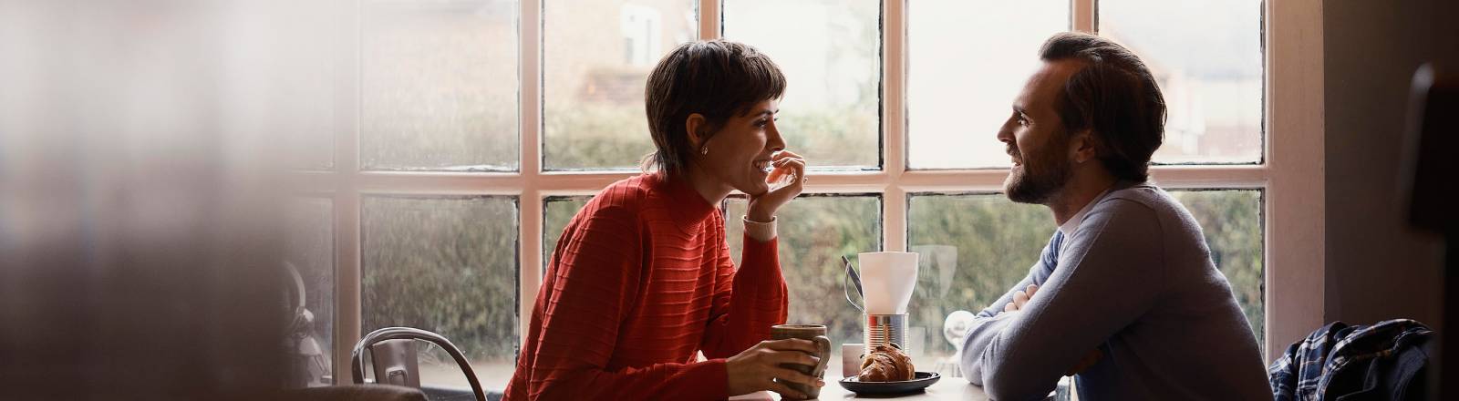 Eine Frau und ein Mann sitzen in einem Café und unterhalten sich