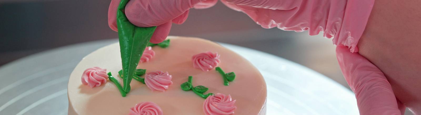 Eine Konditorin verziert eine Torte