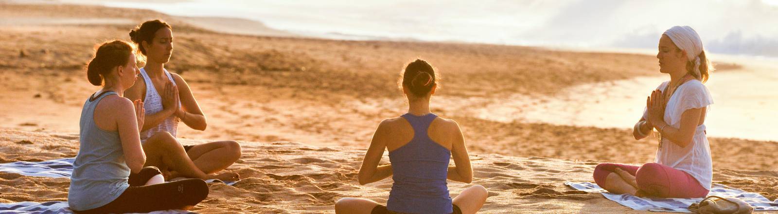 Eine Gruppe macht zusammen Yoga am Strand