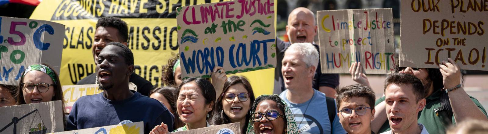 Demonstranten halten vor dem Internationalen Gerichtshof in Den Haag Schilder mit "Climate Justice" (dt. Klimagerechtigkeit) und "Court has spoken" (dt. Das Gericht hat gesprochen) (23.7.2025)