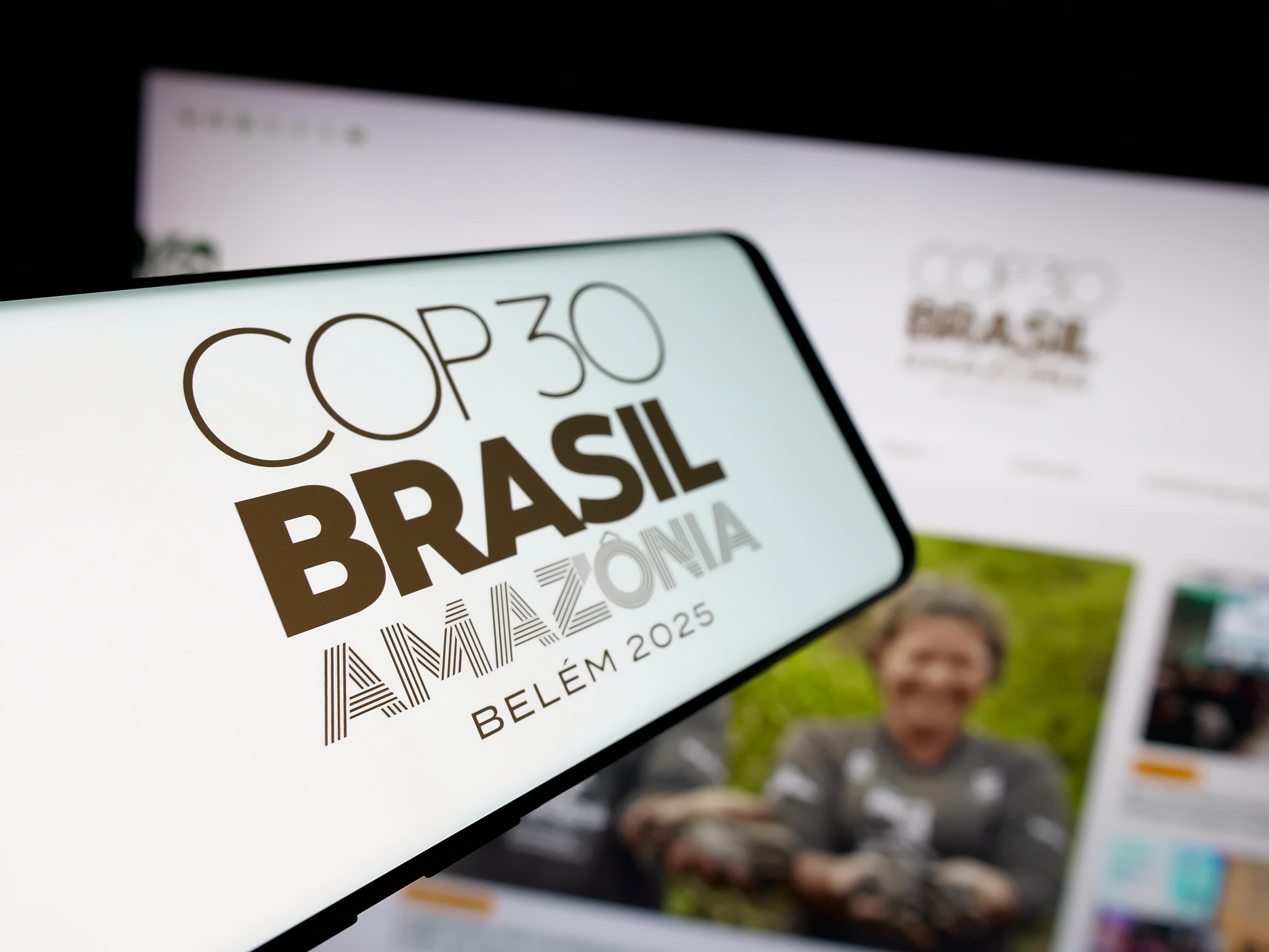 Ein Smartphone mit dem Logo der UN-Klimakonferenz COP30 in Brasilien auf dem Bildschirm vor einer Website.