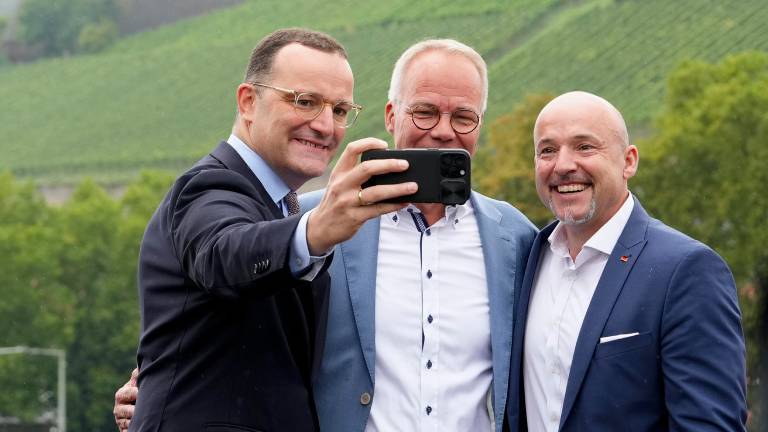 Jens Spahn (CDU) macht ein Selfie von sich, Alexander Hoffmann (CSU) und Matthias Miersch (SPD) auf der alten Mainbrücke in Würzburg (28.08.2025)