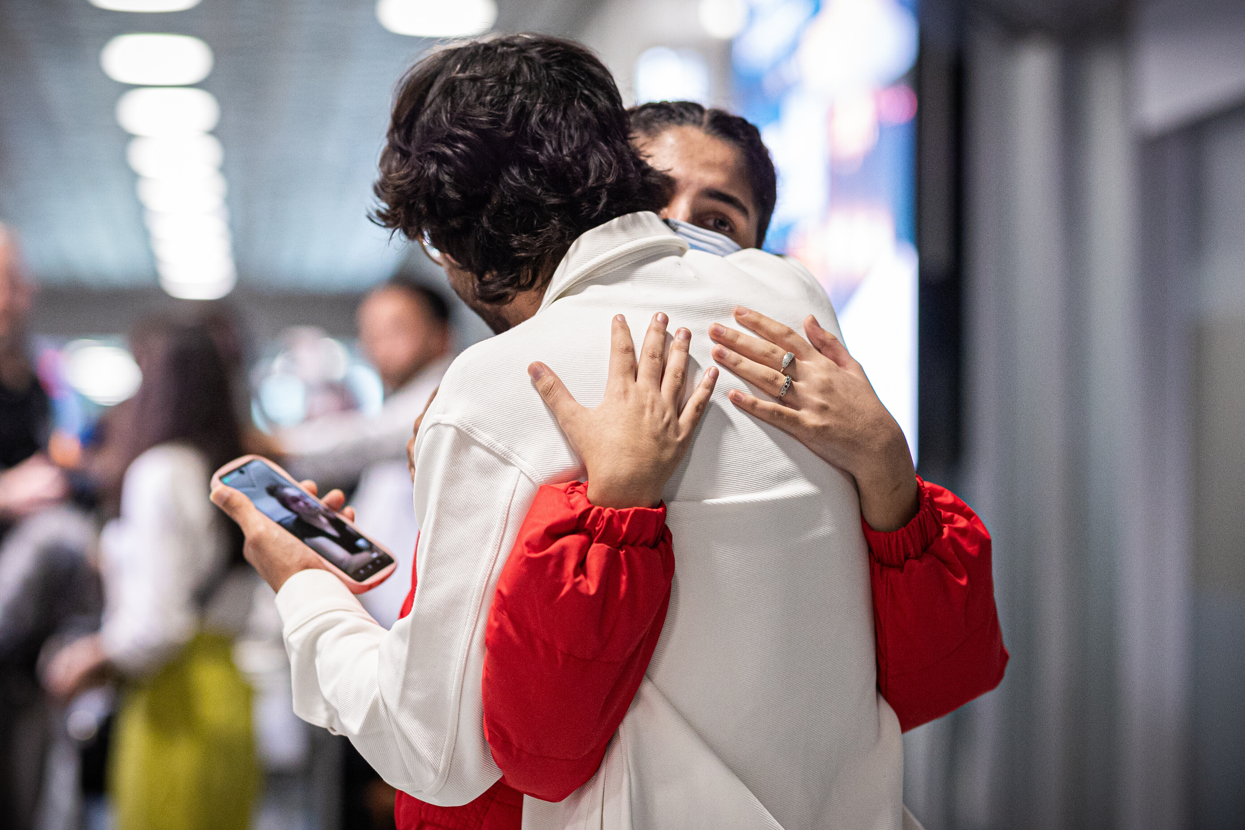 Menschen aus Afghanistan, die zuvor mit einem Flugzeug auf dem Flughafen Hannover-Langenhagen gelandet sind, umarmen sich.