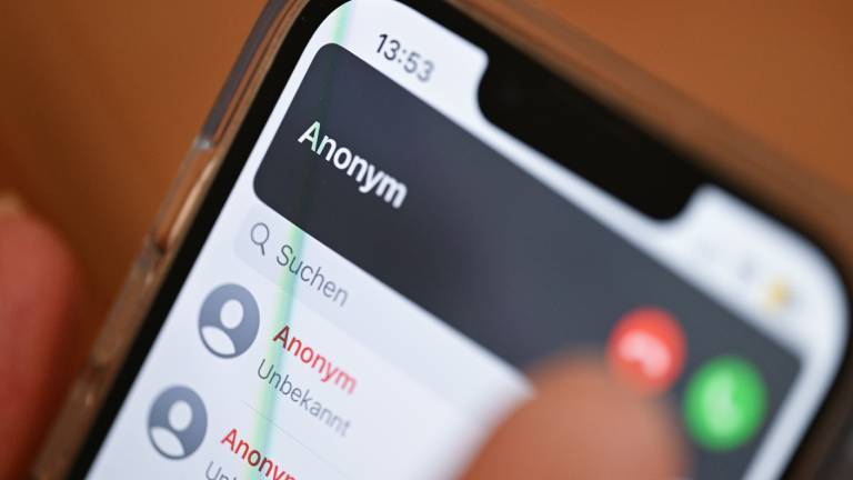 Eine Hand hält ein Smartphone, auf dem ein anonymer Anrufer angezeigt wird