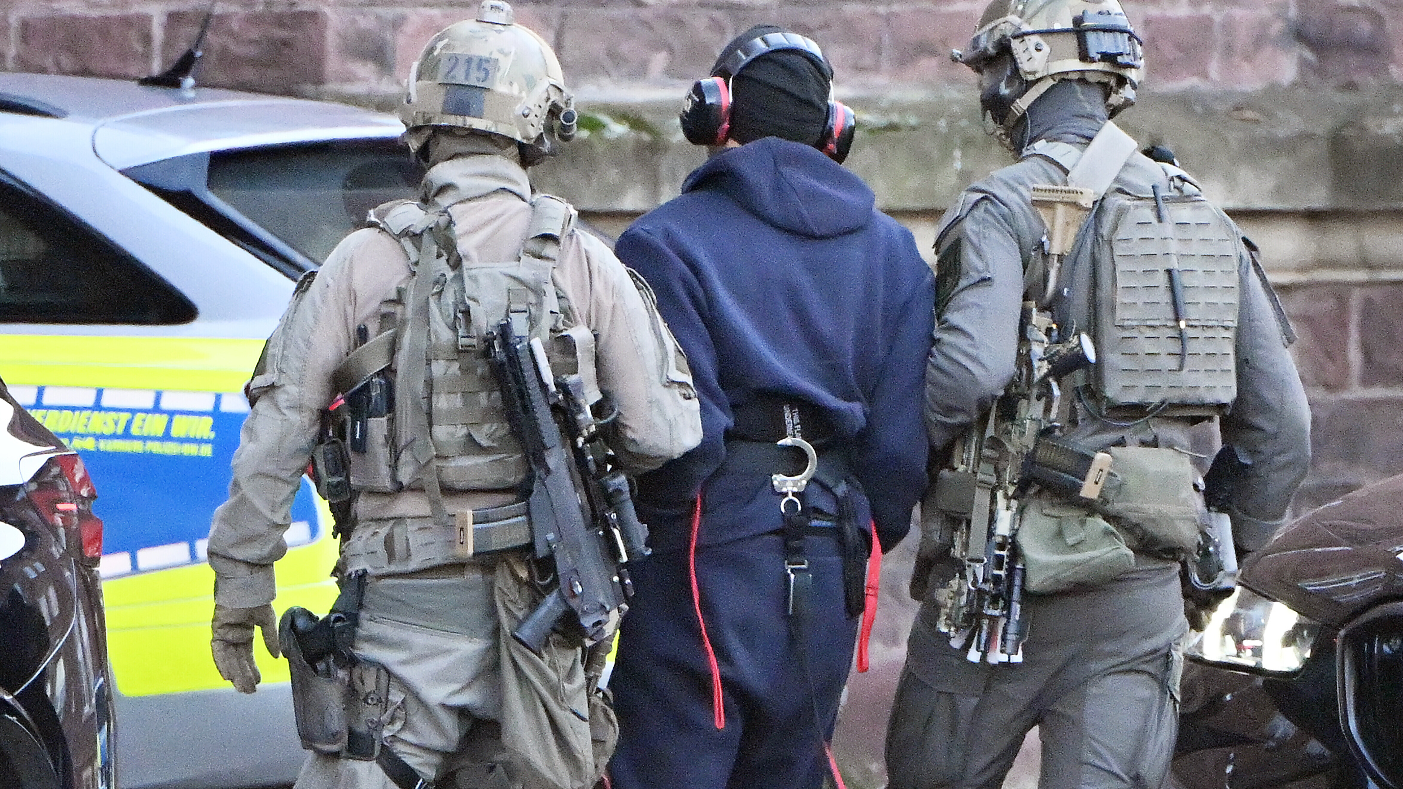 Eine Person wird von einem Hubschrauber zu einer Wagenkolonne geführt. Ein mutmaßlicher Drahtzieher der Anschläge auf die Nord-Stream-Gasleitungen soll von Italien nach Deutschland überstellt werden.