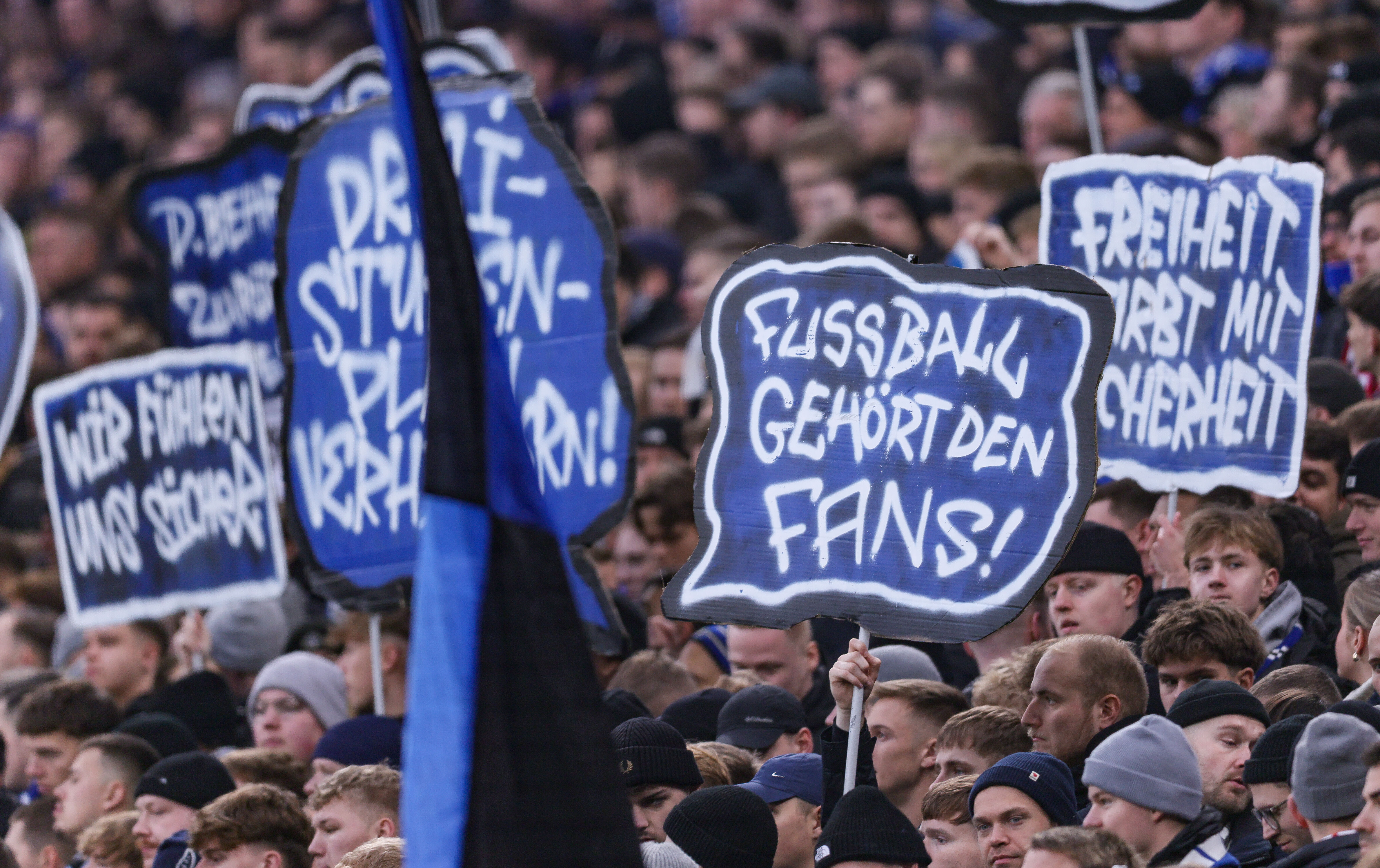 Am 30.11.2025 ein Spiel in der Fussball-Bundesliga; Hamburger SV gegen VfB Stuttgart. Fans halten Schilder in die Höhe, darauf steht: Fußball gehört den Fans.