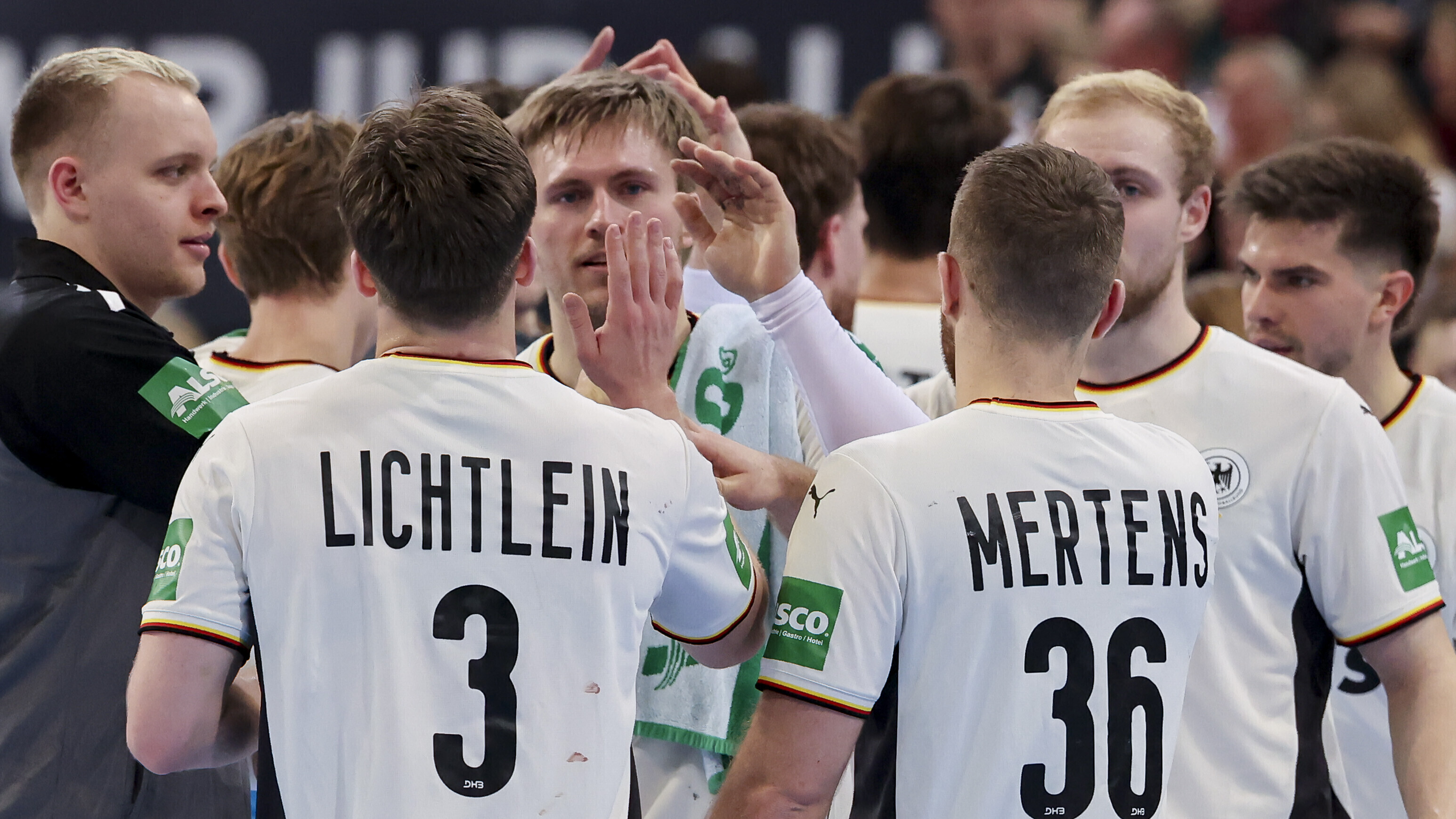 Ein Teil der Handballer der deutschen Nationalmannschaft klatscht sich bei einem Freundschaftsspiel in Hannover ab. Sie stehen dabei auf dem Spielfeld.