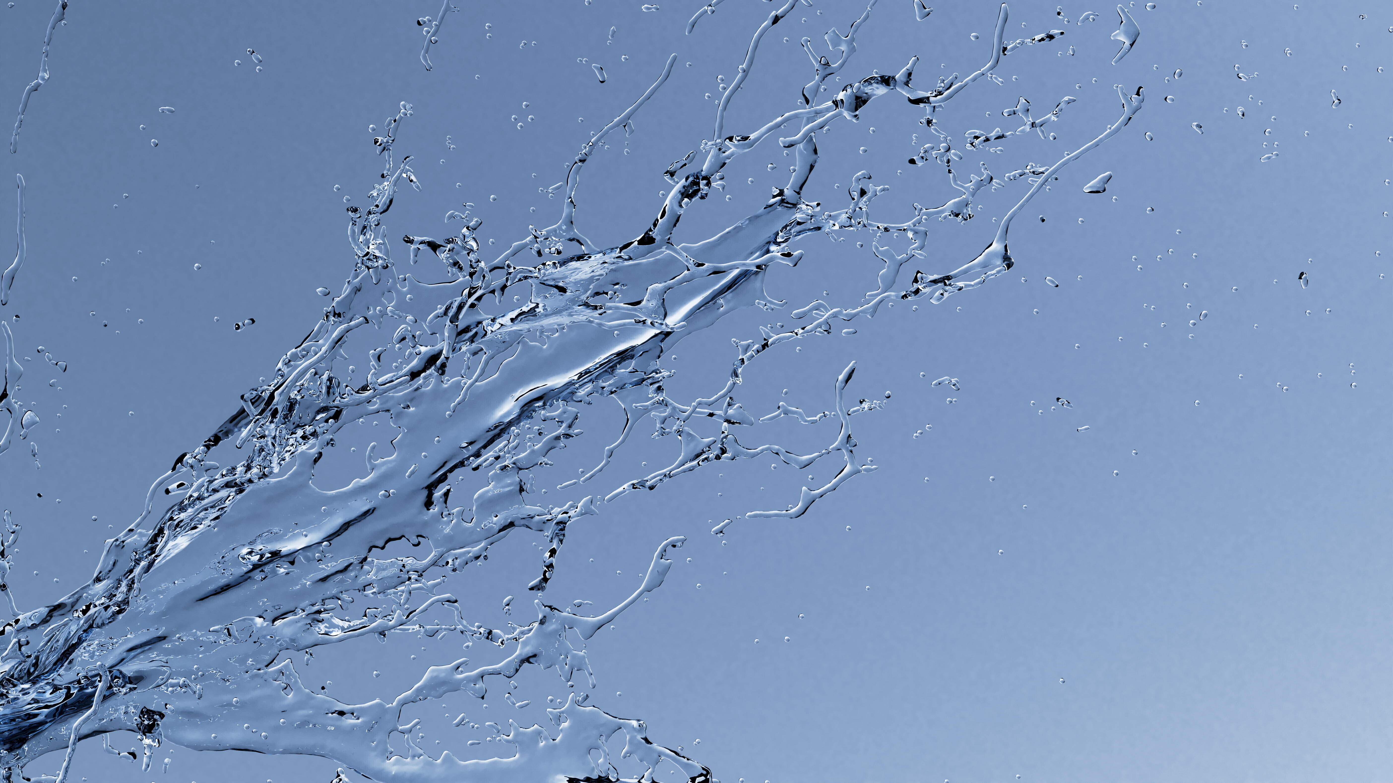 Spritzendes Wasser vor blauem Hintergrund