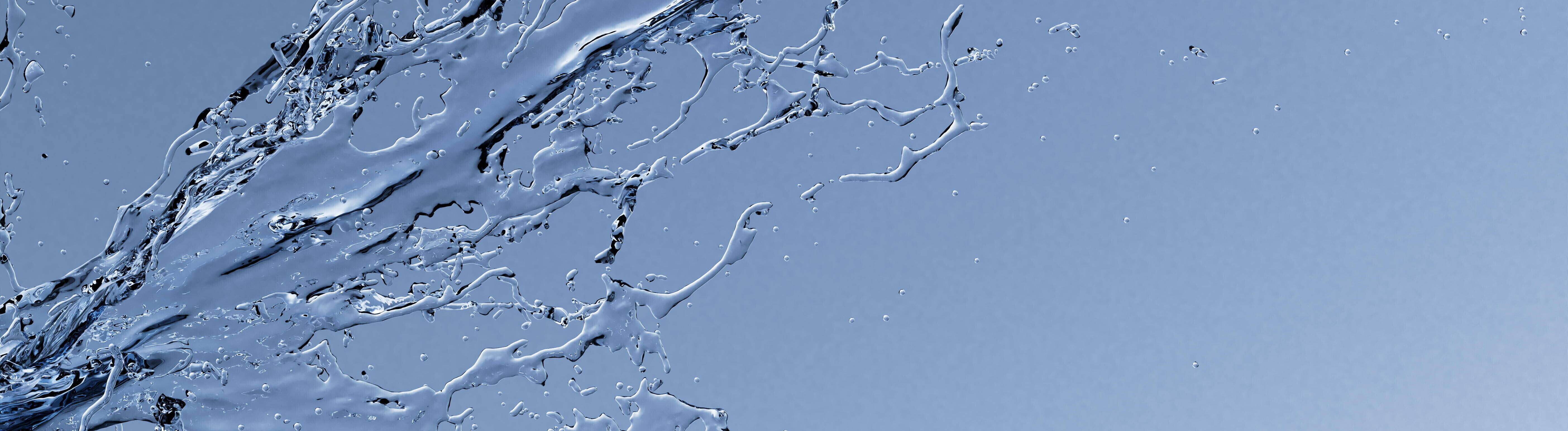 Spritzendes Wasser vor blauem Hintergrund