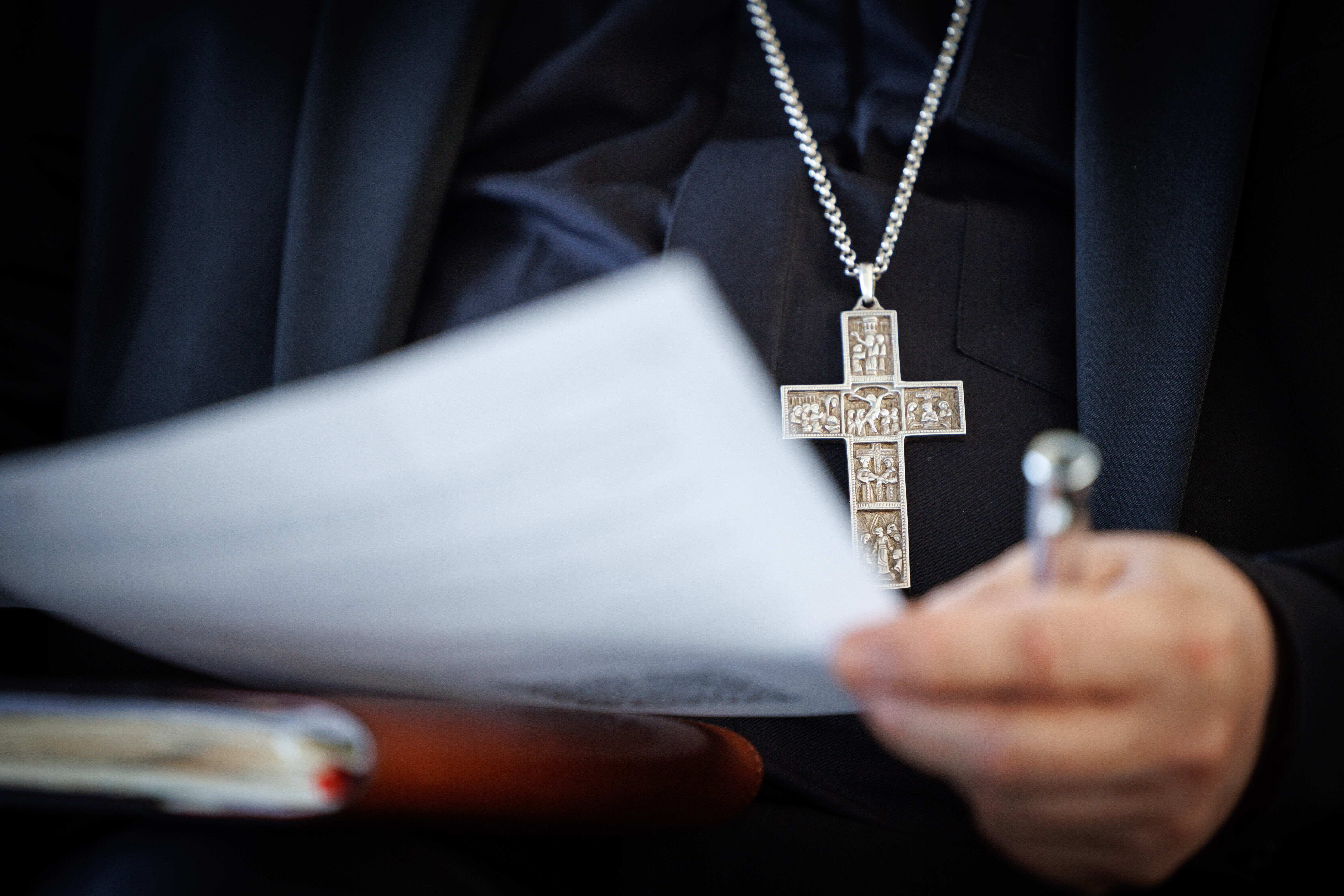 In Paderborn wird eine Studie zu sexuellem Missbrauch im Erzbistum vorgestellt. Erzbischof Bentz hält ein Papier in der Hand. Er trägt ein schwarzes Hemd und eine schwarze Jacke sowie eine Kette mit einem silbernen Kreuz. Lediglich seine Hand, das Papier und der Oberkörper sind im Bild.