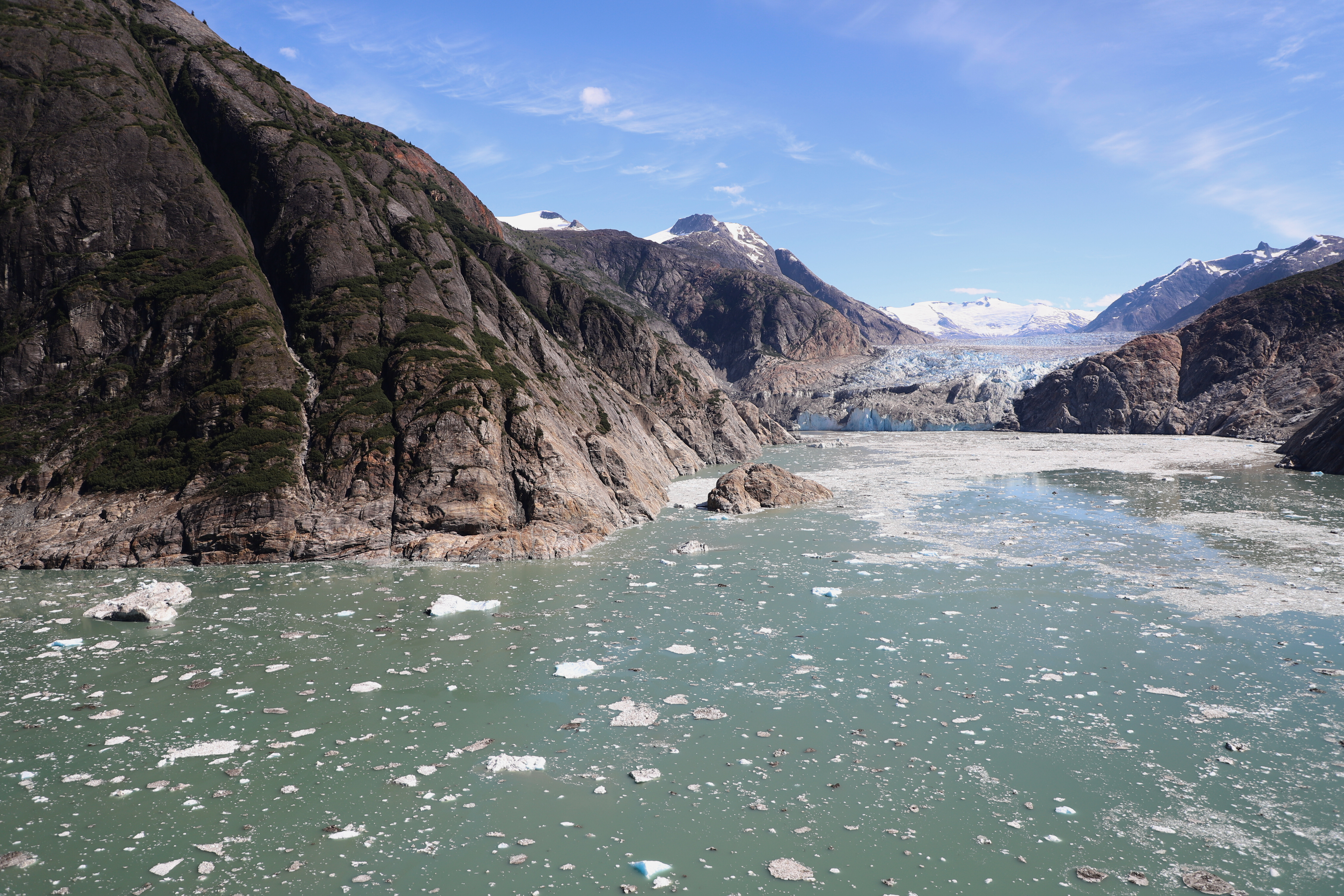 Blick auf das Tracy Arm Fjord in Alaska. Berge ragen in die Höhe, Wasser mit Eis und im Hintergrund ein Gletscher. Hier soll sich im Sommer 2025 ein Tsunami ereignet haben.